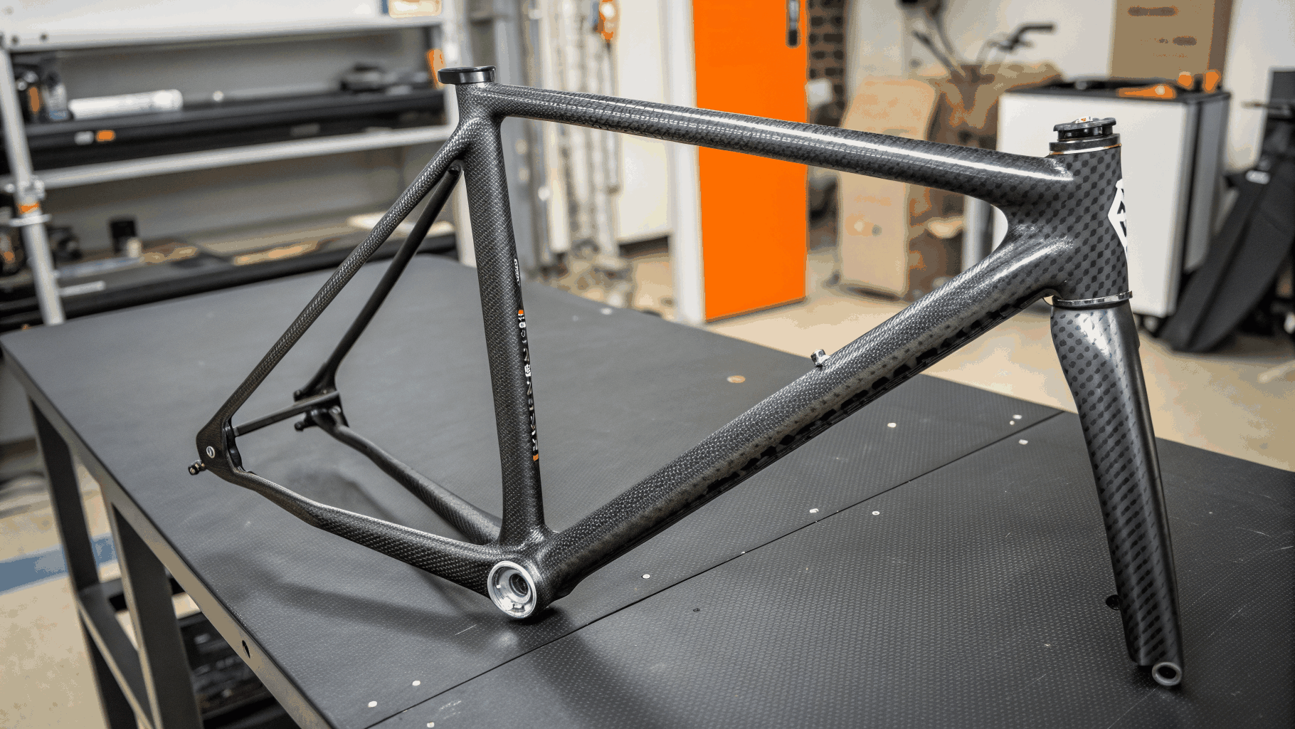 Carbon-fiber additive prototype component beside digital caliper